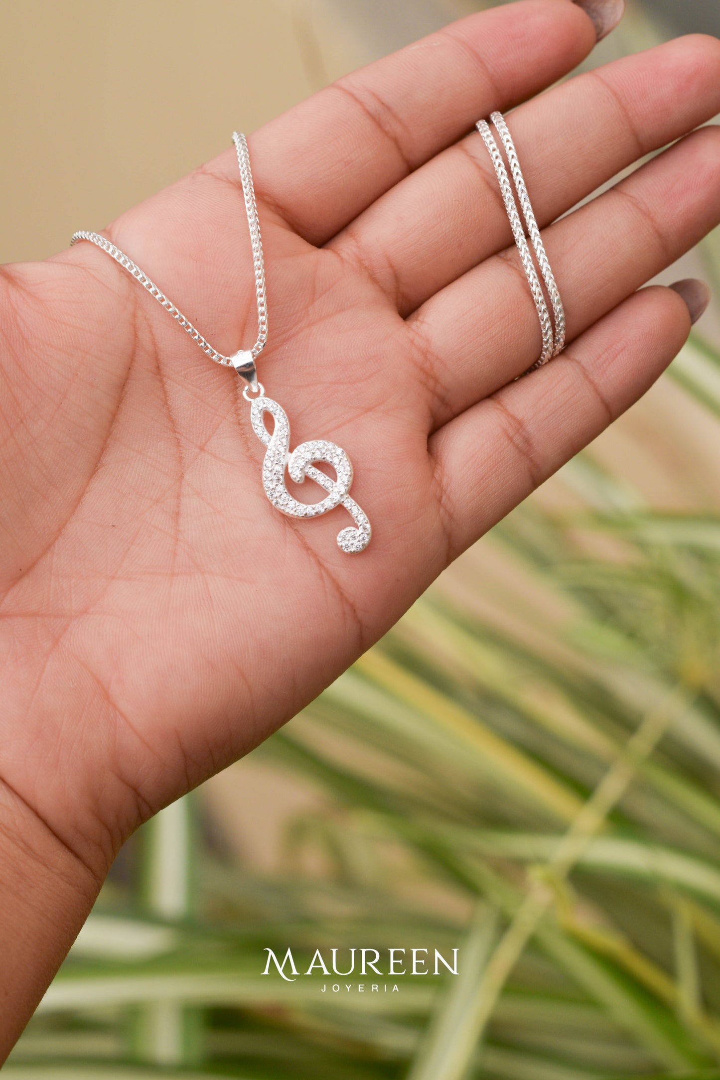 Dije nota musical con piedras