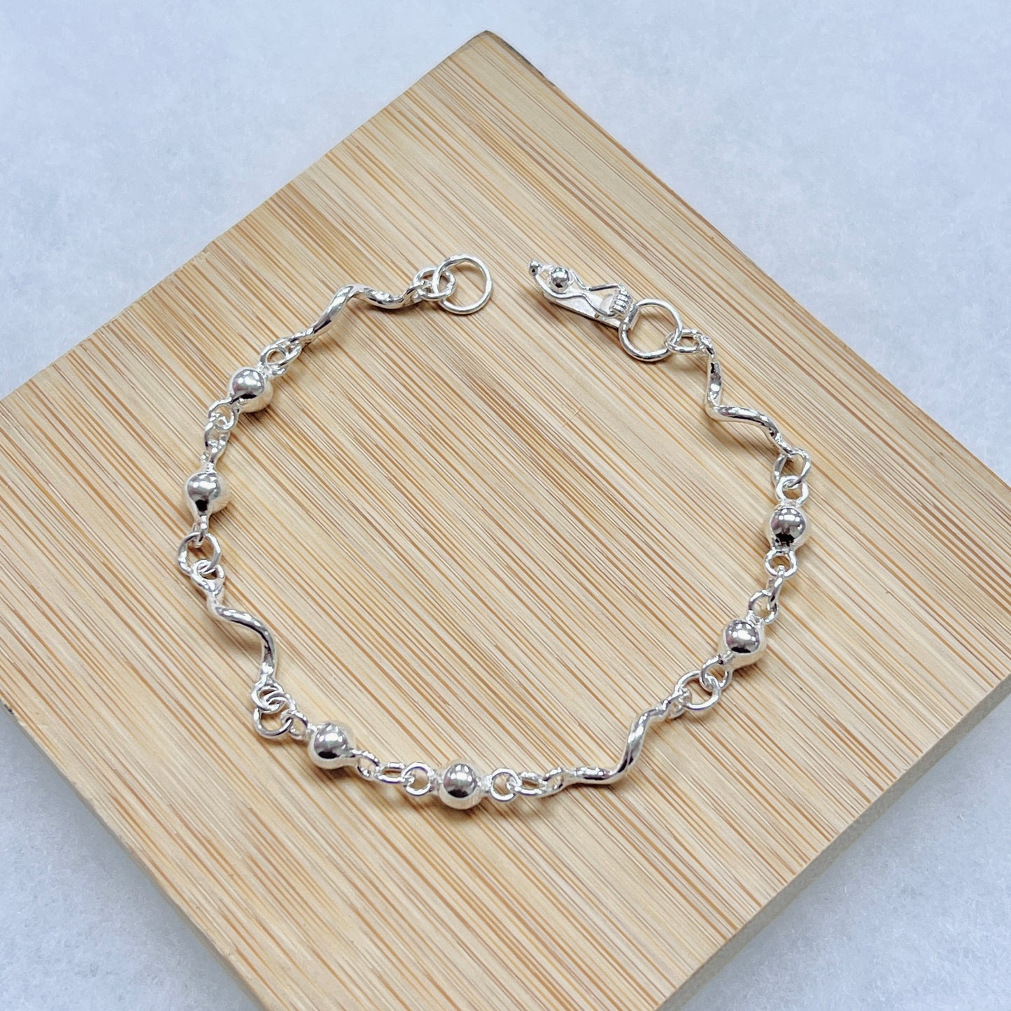 Pulsera esferas pequeñas con tubos ondeados - plata