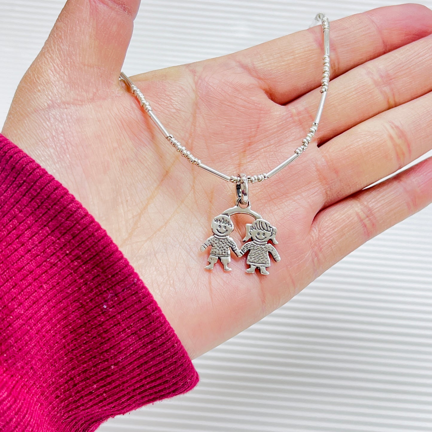 Dije niño y niña juntos - plata quemada