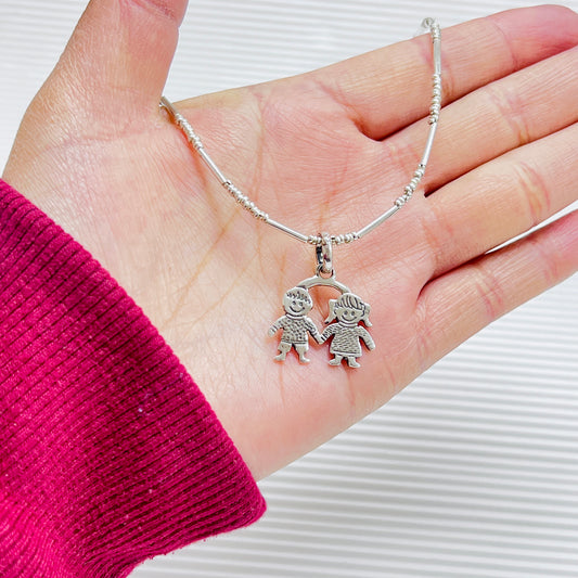 Dije niño y niña juntos - plata quemada