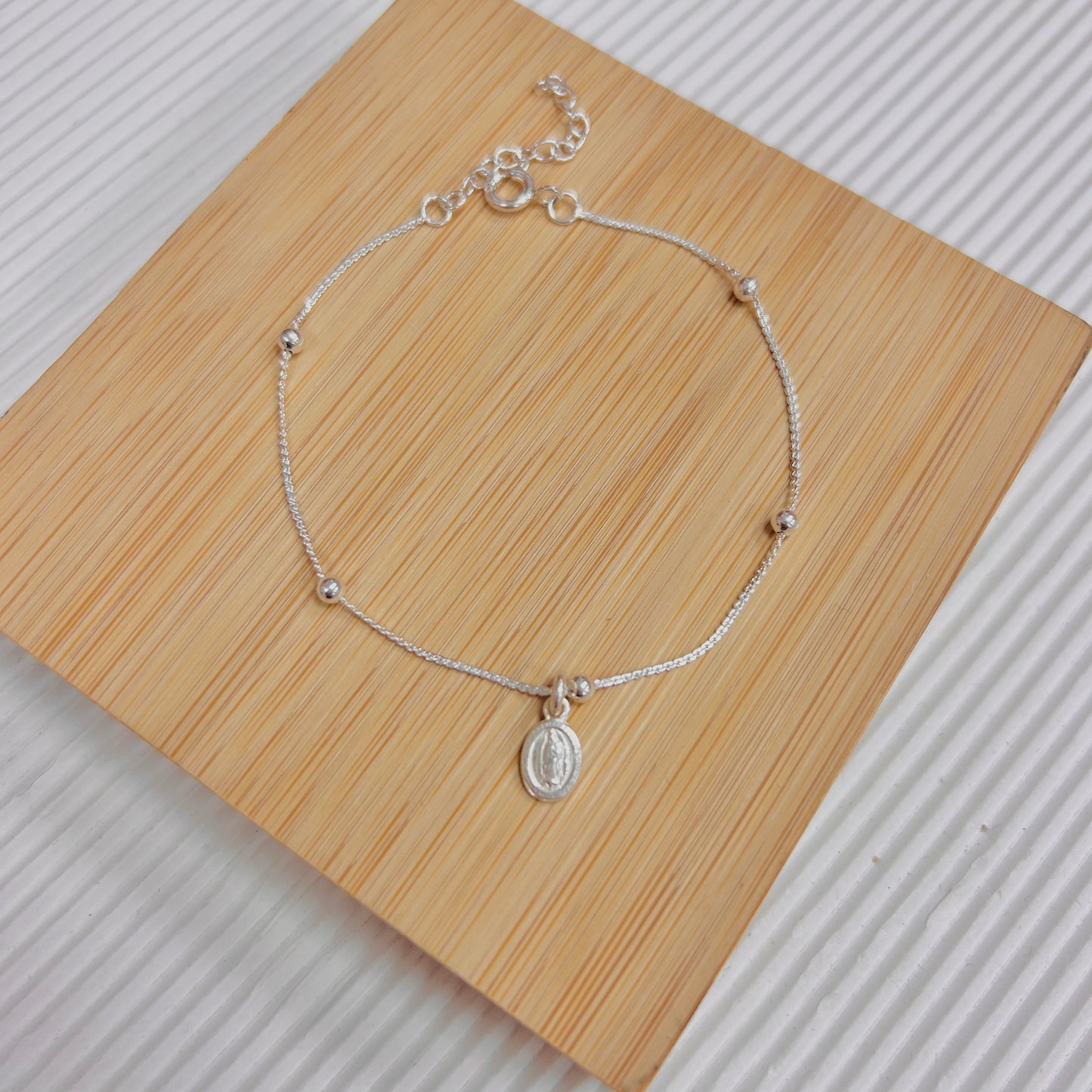 Pulsera esferas y mini dije san benito - plata