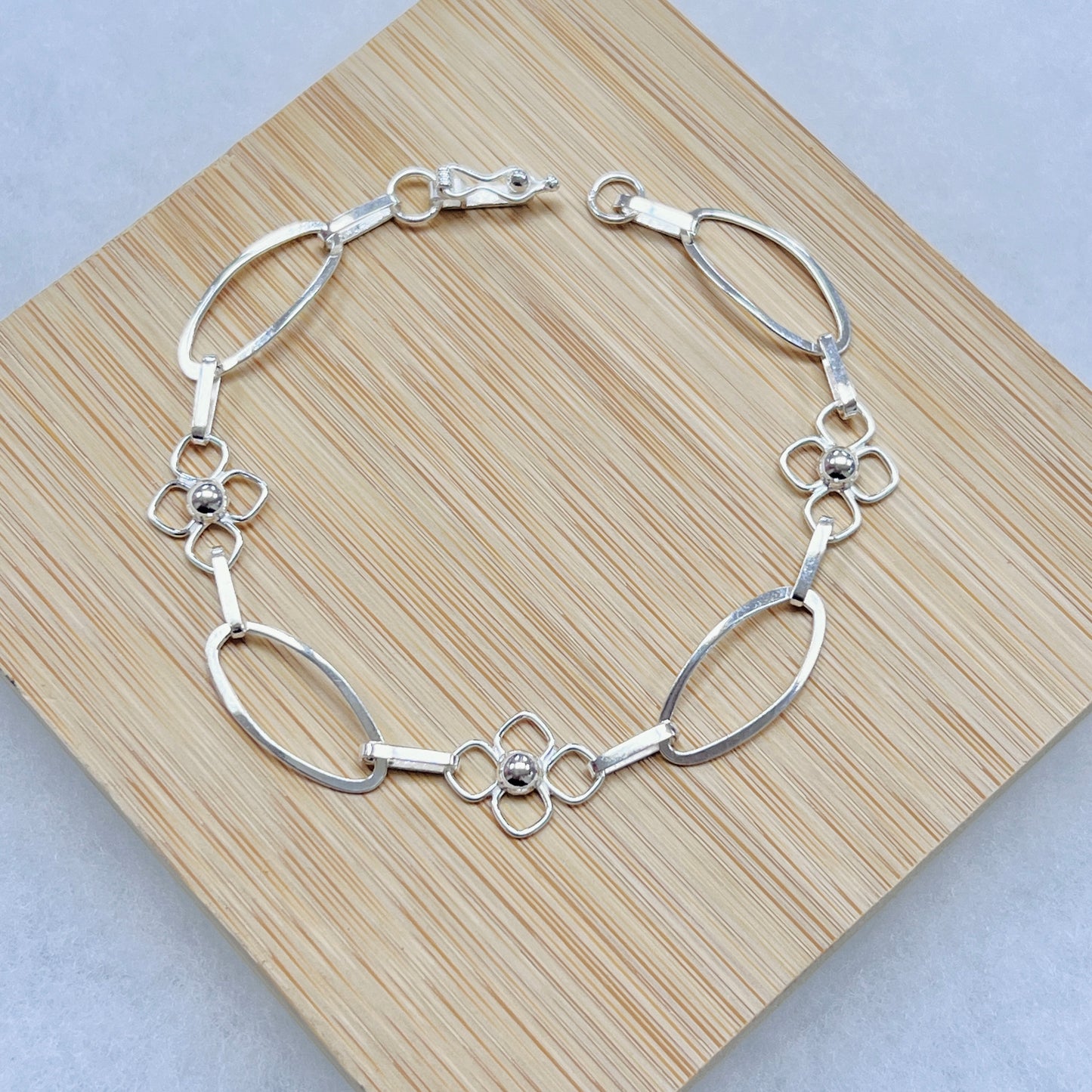 Pulsera delgada flor con ovales calados - plata
