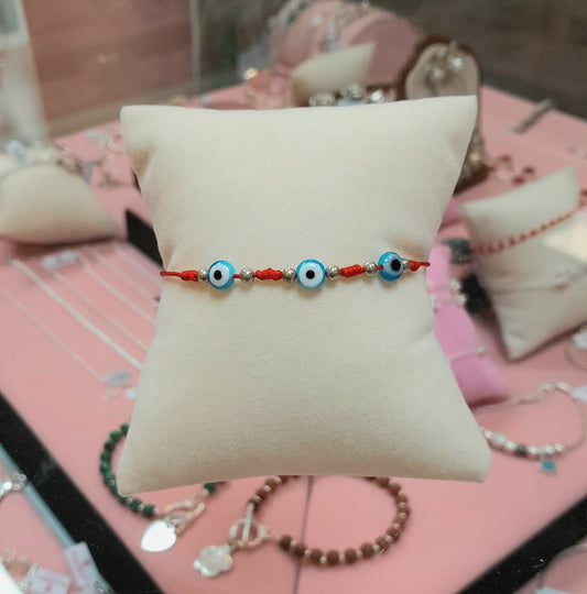 Pulsera ajustable  ojos turcos celeste hilo rojo - Plata