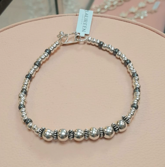 Pulsera rigida con 6 esferas medianas, donas lisas y entorchada- Plata quemada